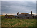 Abandoned cottages.  Scurdy Ness lighthouse behind. in DD10 9SE