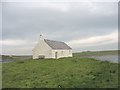 The whitewashed St Cwyfan's Church in LL63 5YR