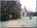 Path underneath the yew tree at St Mary's, Newton Valence in GU34 3RH