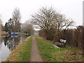 Canal towpath with bench and milepost in UB8 1PW
