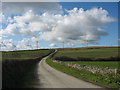 Country road in col between drumlins in Llanbadrig Community