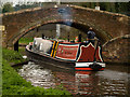 Canal boat passes Milford (Bridge 105), Staffs & Worcs Canal,Staffordshire. in ST17 0UW