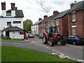Tractor passing the Golden Lion Inn, Tipton St John in EX10 0FF