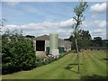 A lawn with trees, beside a 20th century farm barn, near Tring Station in HP23 5QX
