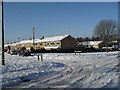 Junction of a snowy Longstock Road and Leckford Road in PO9 5PH