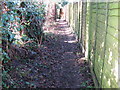 Footpath west between Churchfield Farm on the left and houses in Holly Close at West Chiltington in RH20 2QA