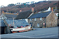 Fishing boat drawn up on a car park at Sennen Cove in TR19 7AY