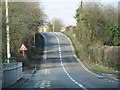 Road past school rises to the bridge over the railway in OX10 9QE
