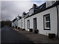 Row of cottages  across from phone box by river Coiltie in IV63 6UU