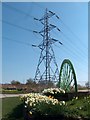 Pit-head wheel and daffodils with pylon at eastern edge of Treeton village in S60 5QU