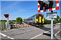 Unit 156422 speeds past the level crossing in NR34 8LL