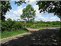 Cyclist passing joint entrance to Redland Farm and Ingrams Farm in RH14 0JA
