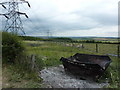 Burnt out skip, cattle and pylons in S44 5BX
