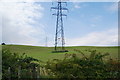 Pylons over a grassy hill in OL12 7TR