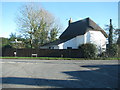 Thatched cottage by a road junction in Winterbourne Kingston in DT11 9BN
