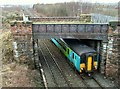 Train passing under disused bridge in CA1 3TJ