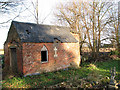 Brick building in Gedney Hill Holy Trinity churchyard in Gedney Hill