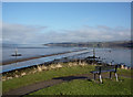 Seat at the tip of the park area of Ferry Point in IV15 9QU