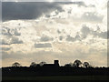Silhouette of Corpusty church against a darkening sky in NR11 7BG