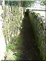 Footpath between 2 drystone walls, near Haworth in BD22 0EJ