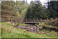 A footbridge over a dry looking waterway at the head of the reservoir in North Turton