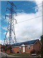 House with solar panels beneath electricity pylon at Ormes Meadow in S20 7LL