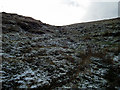 A steep climb to Drybedd with a sprinkling of snow on the grass in Blaenrheidol Community