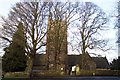 Tower of St Briavels church behind tall trees in GL15 6RW