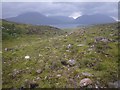 Boulder strewn grassland with Ob Mheallaidh beyond in IV54 8XY