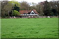 Black and white cattle in front of a black and white house in LU7 0UB