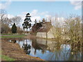 Middle farm buildings reflected in pond in OX2 8HD
