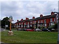 Row of terraced houses and village sign, Earl's Barton in NN6 0EP