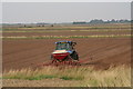 Seed drill at work behind the sea wall in LN11 7RA