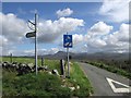 Road signs and distant Rhinogs in LL46 2TS