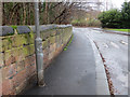 Higher Lane, Fazakerley, a sandstone wall, and a bench mark in L9 7LG