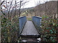 Across a footbridge over a stream near Monmouth Street Perthcelyn in CF45 3YJ