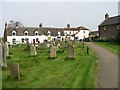 View of churchyard and thatched cottages in NR29 5NW