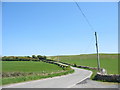 A sweeping curve in the Brynteg-Maenaddwyn road viewed from the gate of Nant Isa' in LL78 7JF