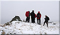 Cairn on knoll with walking party in Shap Rural