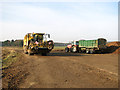Sugar beet harvester and tractor parked by St Peter's church in NR10 4QE