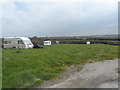 Field with scattered semi-derelict caravans in PL28 8JF
