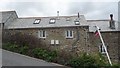 Cottages on the steep hill away from Mawgan Porth in TR8 4BE