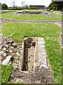 Looking west across ruins at Muchelney with tomb in foreground in TA10 0DG