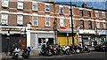 Motorcycle parking and shops on Upton Lane in E7 8BX