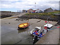 Small boats beached at their moorings in Portsoy New Harbour in AB45 2RS