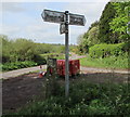 Grimy signpost on a grass triangle in Poolmill, Bridstow in HR9 6JU