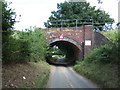 Low arched railway bridge over Brickkiln Lane in NR15 1QB