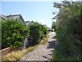 Coastal footpath passing houses at the west end of East Wittering in PO20 8LQ
