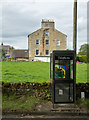 Telephone box with house beyond in DL12 9DA