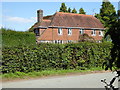 House on Mill Lane seen from footpath junction in RH13 8ED